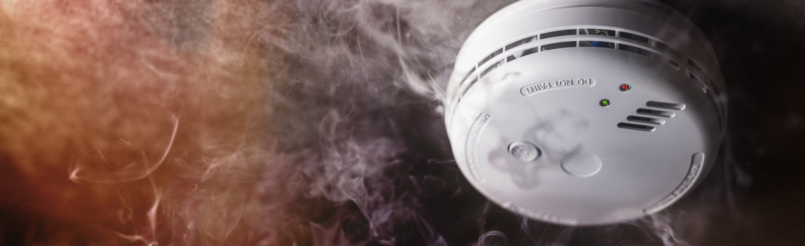 Smoke detector and fire alarm in action background stock photo