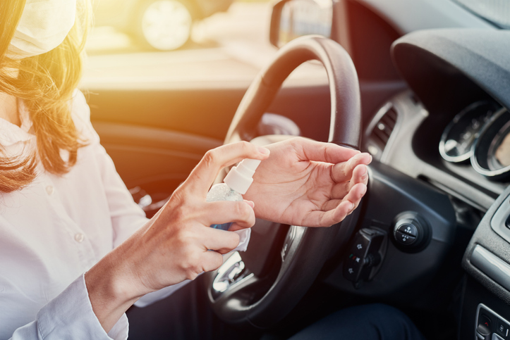 Person using hand sanitizer in the car