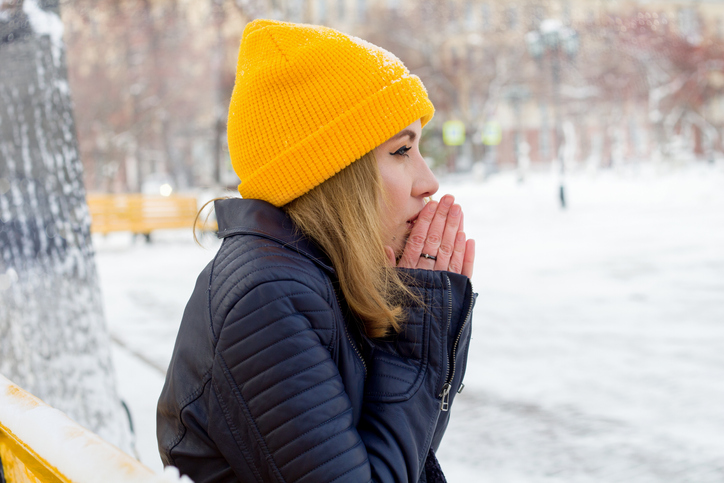 woman blowing on her hands