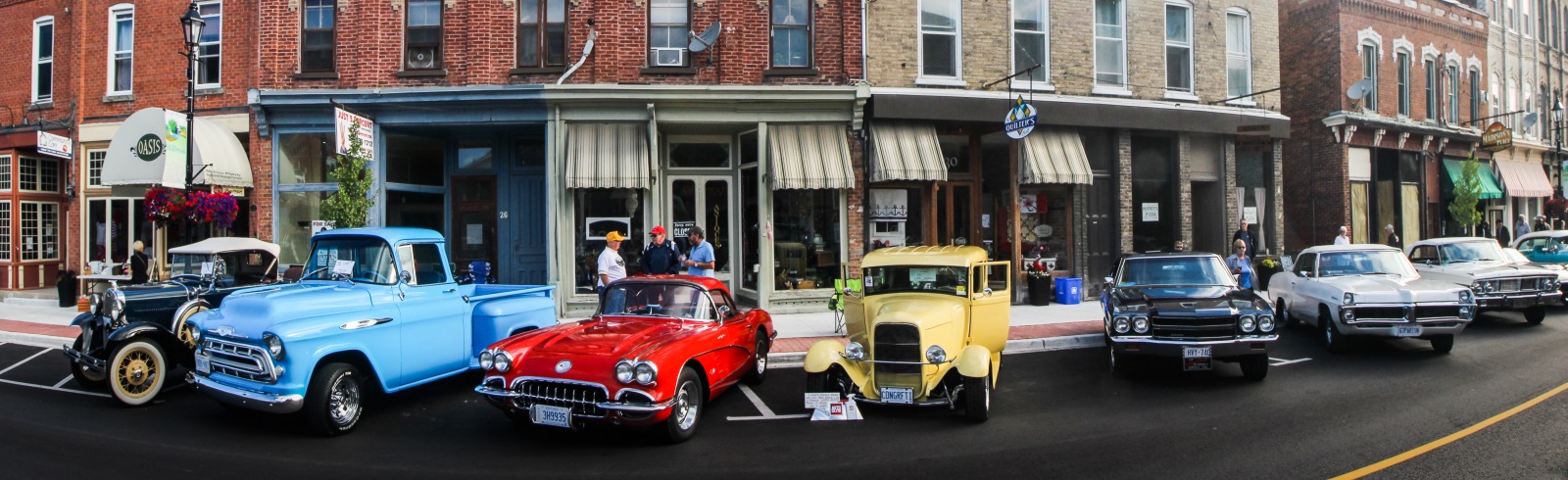 vintage cars lined up in front of stores