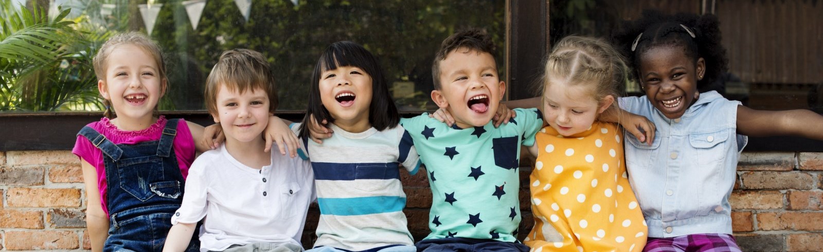 children sitting on a bench laughing